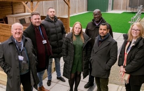 Group of seven people standing i newly refurbished children's centre garden in Greenwich